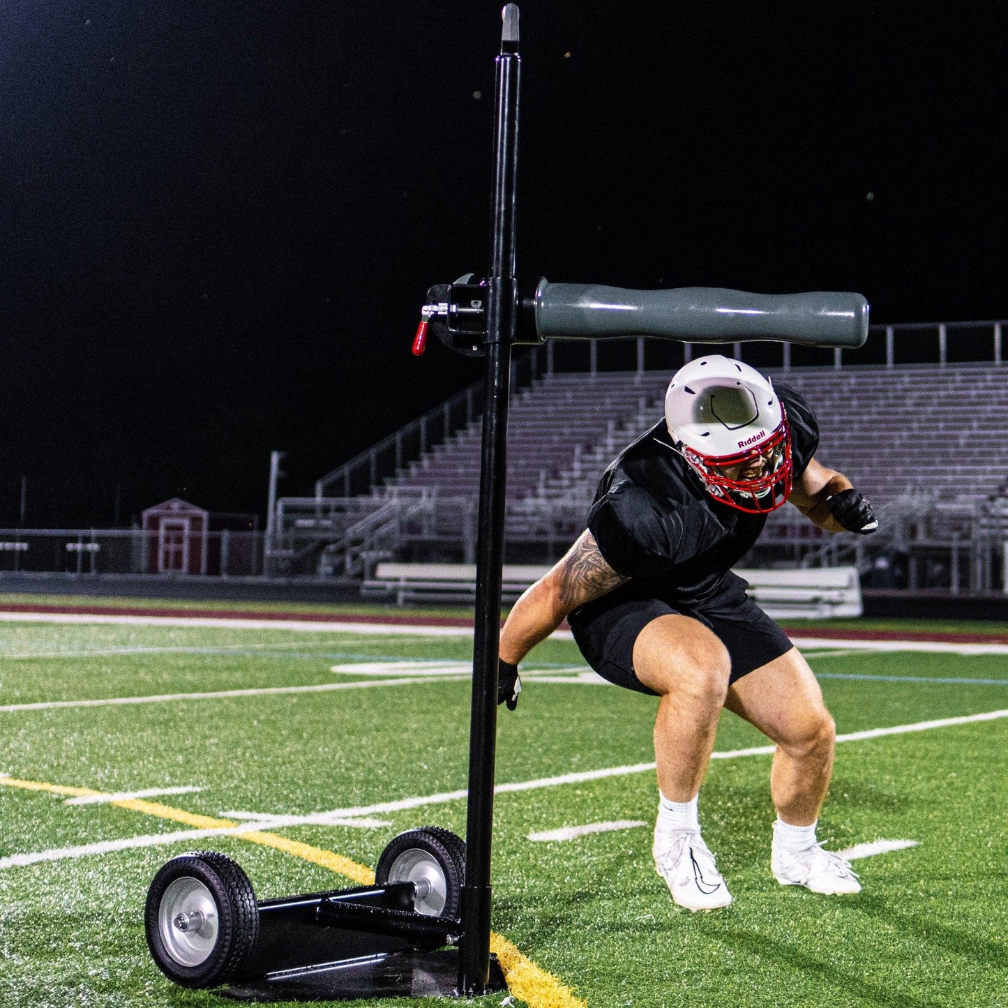 Football Player Bending Under Half-Gate Arm During Football Drill on Football Field